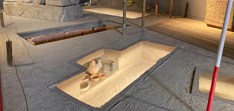 Eine archäologische Ausgrabungsstätte mit Keramikgefäßen in einer Grube.