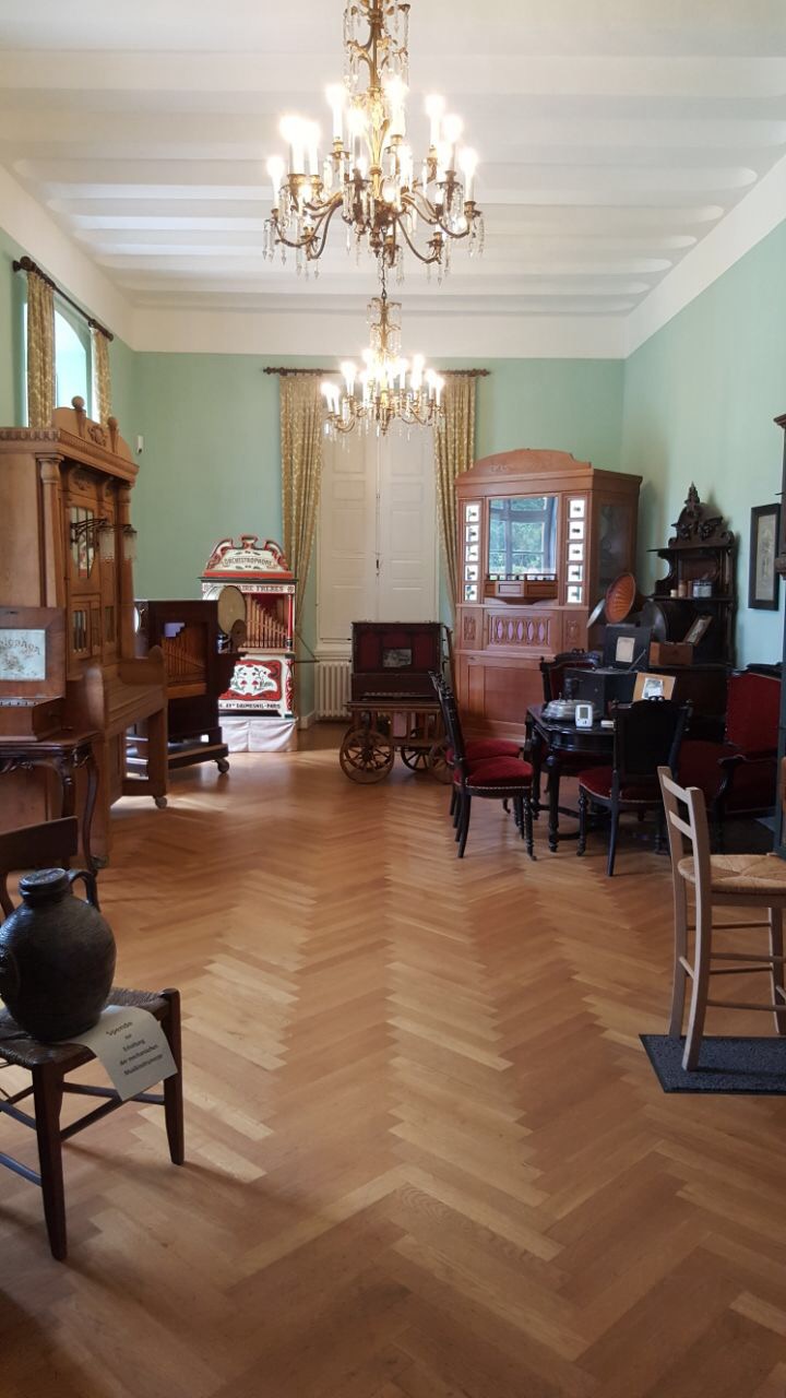 Ein elegantes Vintage-Zimmer mit Holzfußboden, antiken Möbeln und Kronleuchtern.